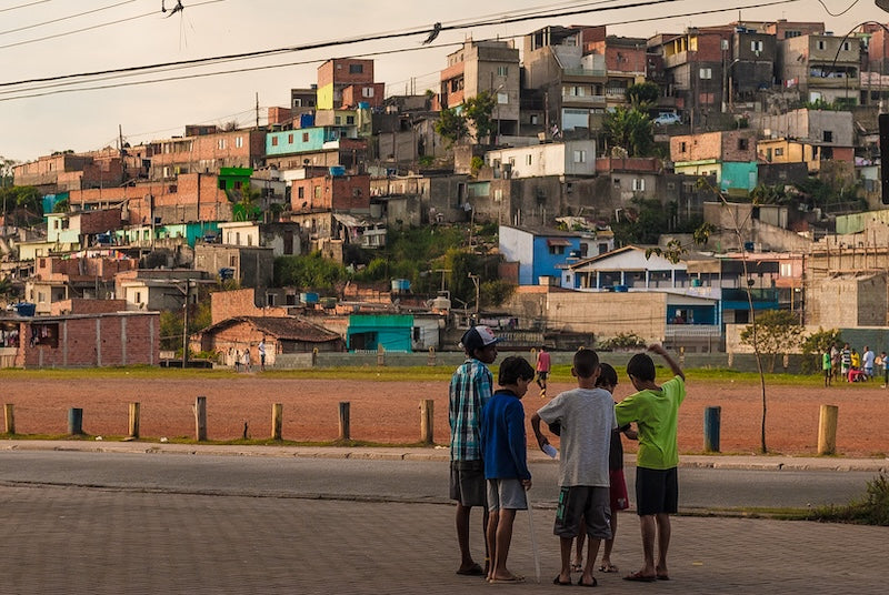 children on the street with houses on the background